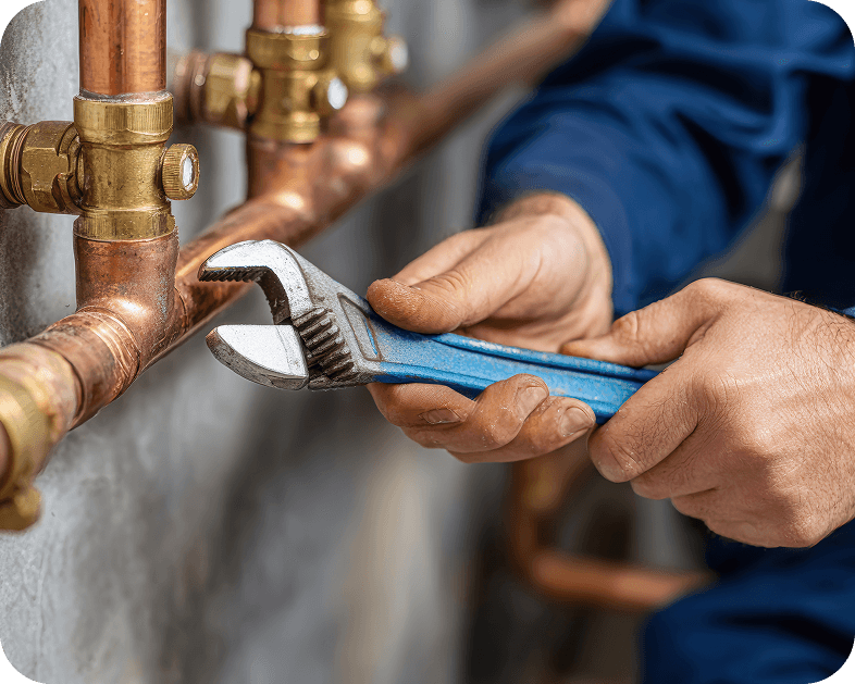 Plumber tightening a fitting on copper pipe with a wrench