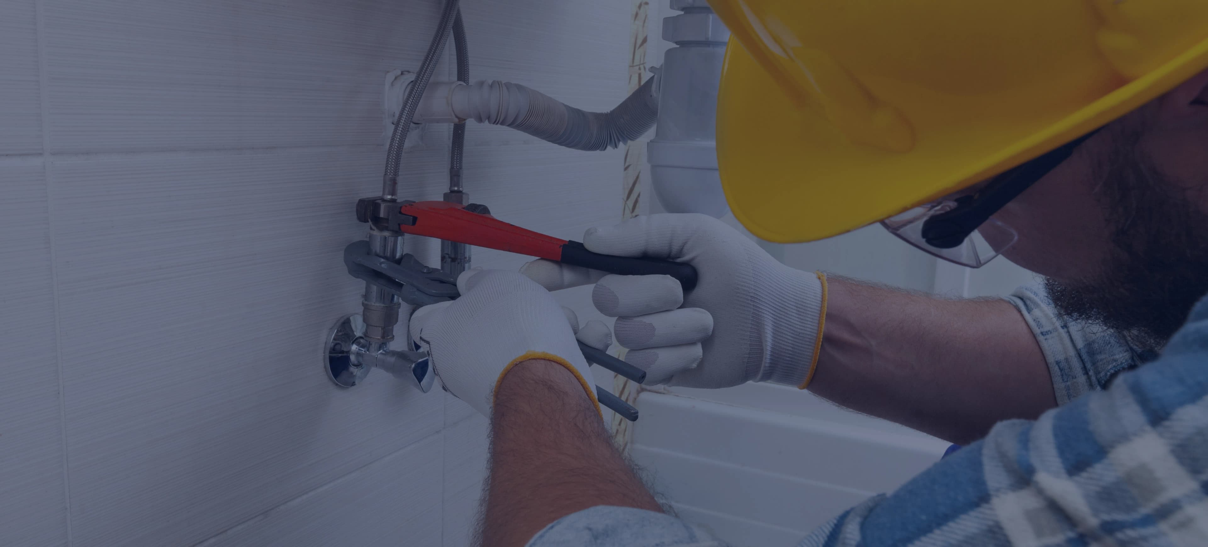 Licensed plumber working on piping