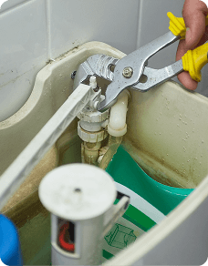 Hands using pliers on a plumbing fixture